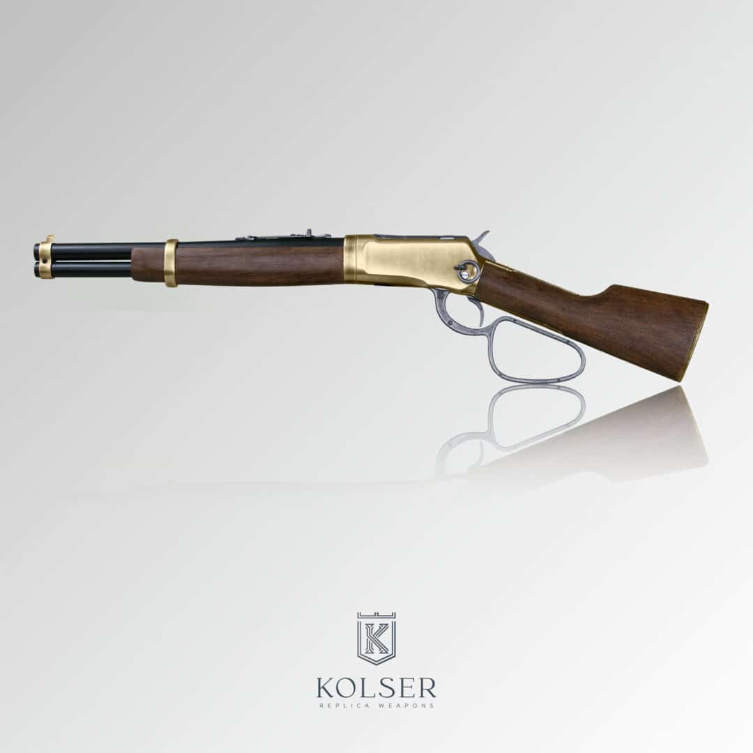 Vista lateral izquierdo de réplica de rifle winchester mares leg 26 pulgadas con cañones en color negro, cuerpo de madera y mecanismo en color dorado.