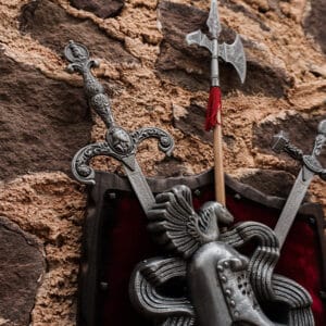 Escudo de armas sobre parece con dos espadas y hacha de doble filo.